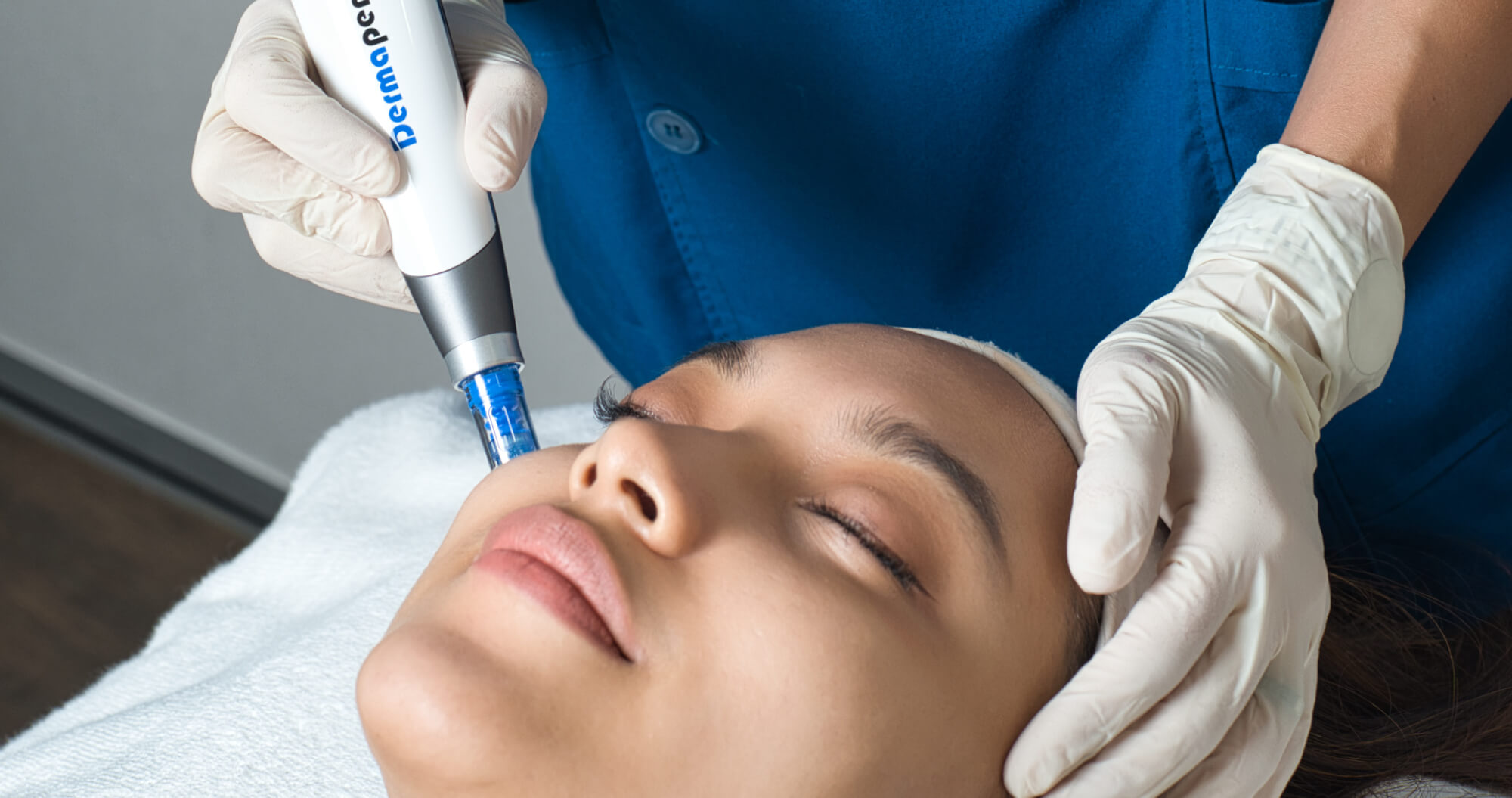 An aesthetician performing facial treatment on a patient, using Dermapen 4.