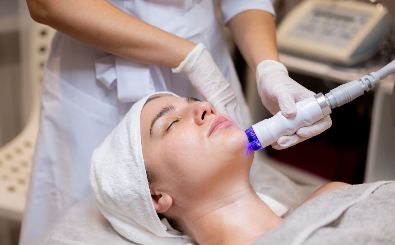 An aesthetician performing facial treatment on a patient’s face, using the latest device.