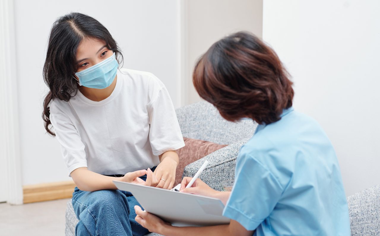 A woman and an aesthetician are in a room, having a consultation.