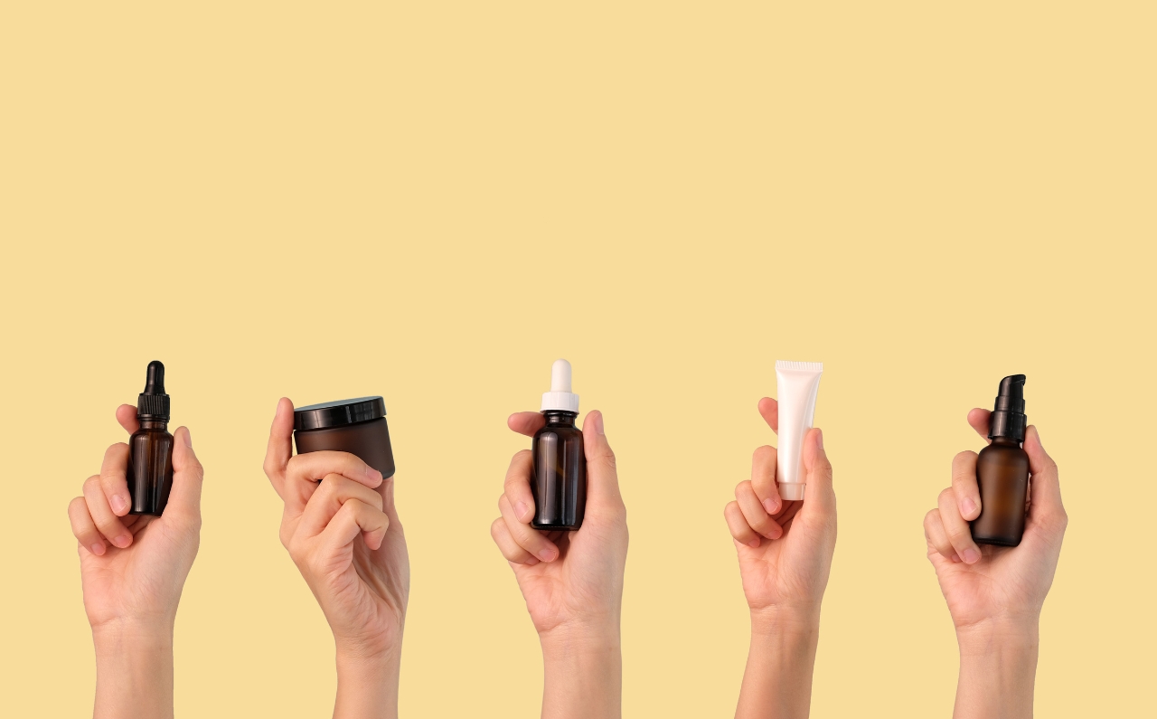 Five individuals, each holding a different skincare product, representing a commitment to a consistent skincare routine.